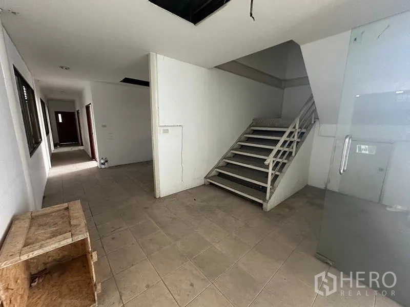 Warehouse for rent in Suan Luang, Bangkok - Ground‑floor lobby with tiled corridor and stairway to upper offices.