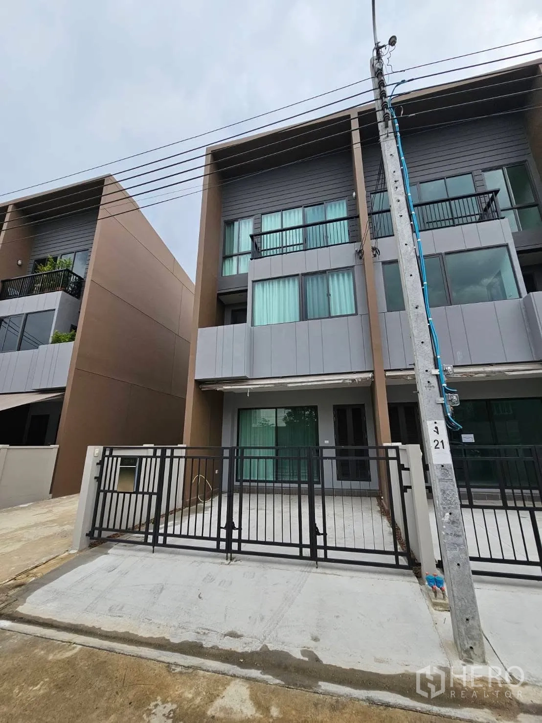 ทาวน์เฮาส์ for rent in Saphan Sung, Bangkok - ด้านหน้าทาวน์เฮ้าส์ 3 ชั้น สไตล์โมเดิร์น มีระเบียงและที่จอดรถหน้าบ้านพร้อมรั้ว