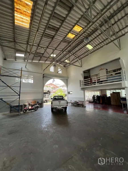 คลังสินค้า ให้เช่าในThung Khru, Bangkok - ภายในมองไปทางประตูทางเข้า มีรถกระบะ ชั้นลอยสำนักงาน และหน้าต่างสว่าง
