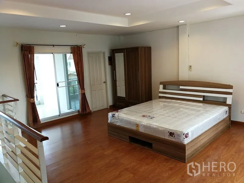 ทาวน์เฮาส์ ให้เช่าในPhasi Charoen, Bangkok - ห้องนอนใหญ่พื้นไม้ มีเตียง ตู้เสื้อผ้า และทางออกสู่ระเบียง