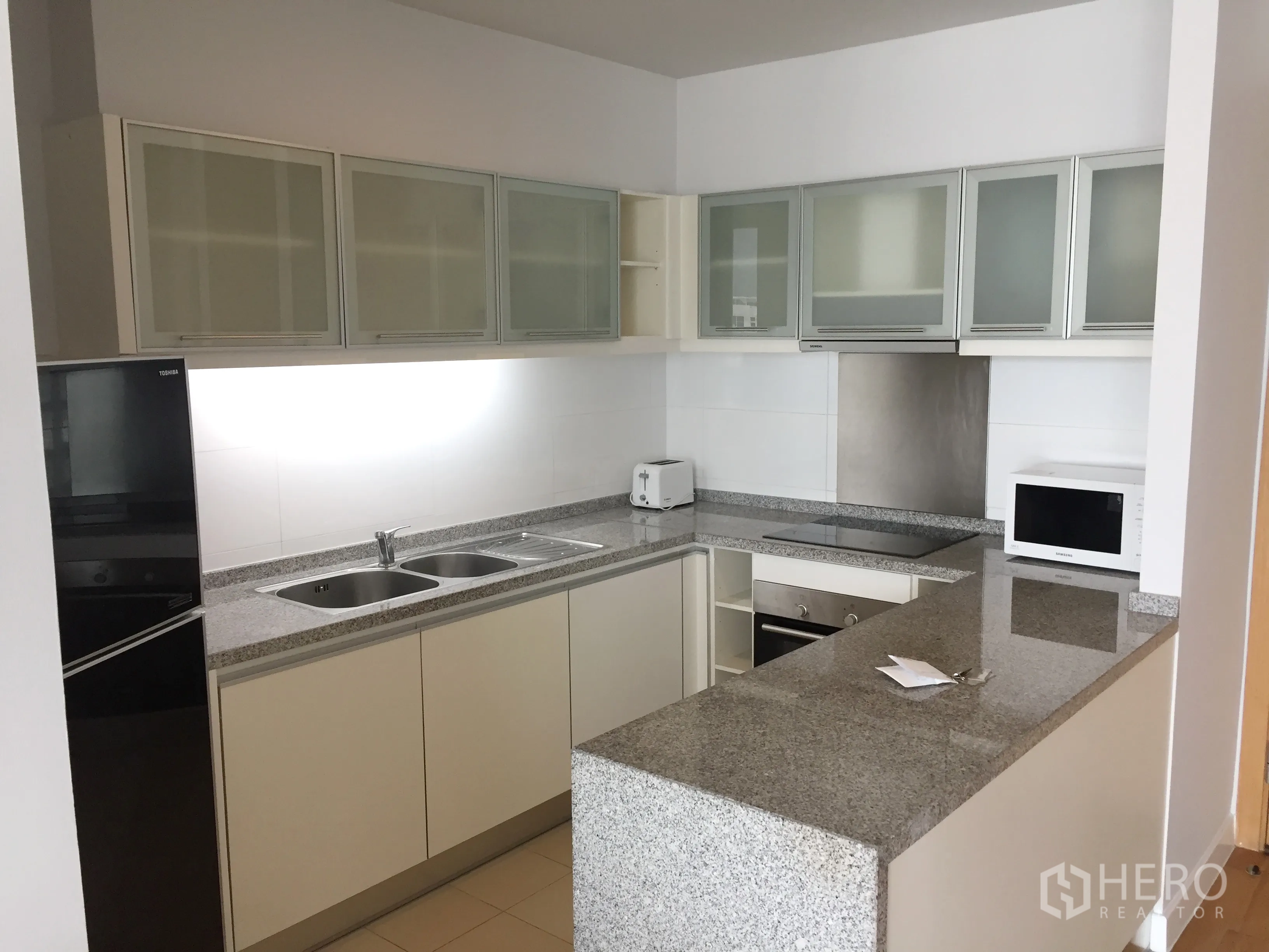 คอนโด ให้เช่าในKhlong Toei, Bangkok - ครัวรูปตัว U เคาน์เตอร์หินแกรนิต ตู้เก็บของ และเครื่องใช้ครบ