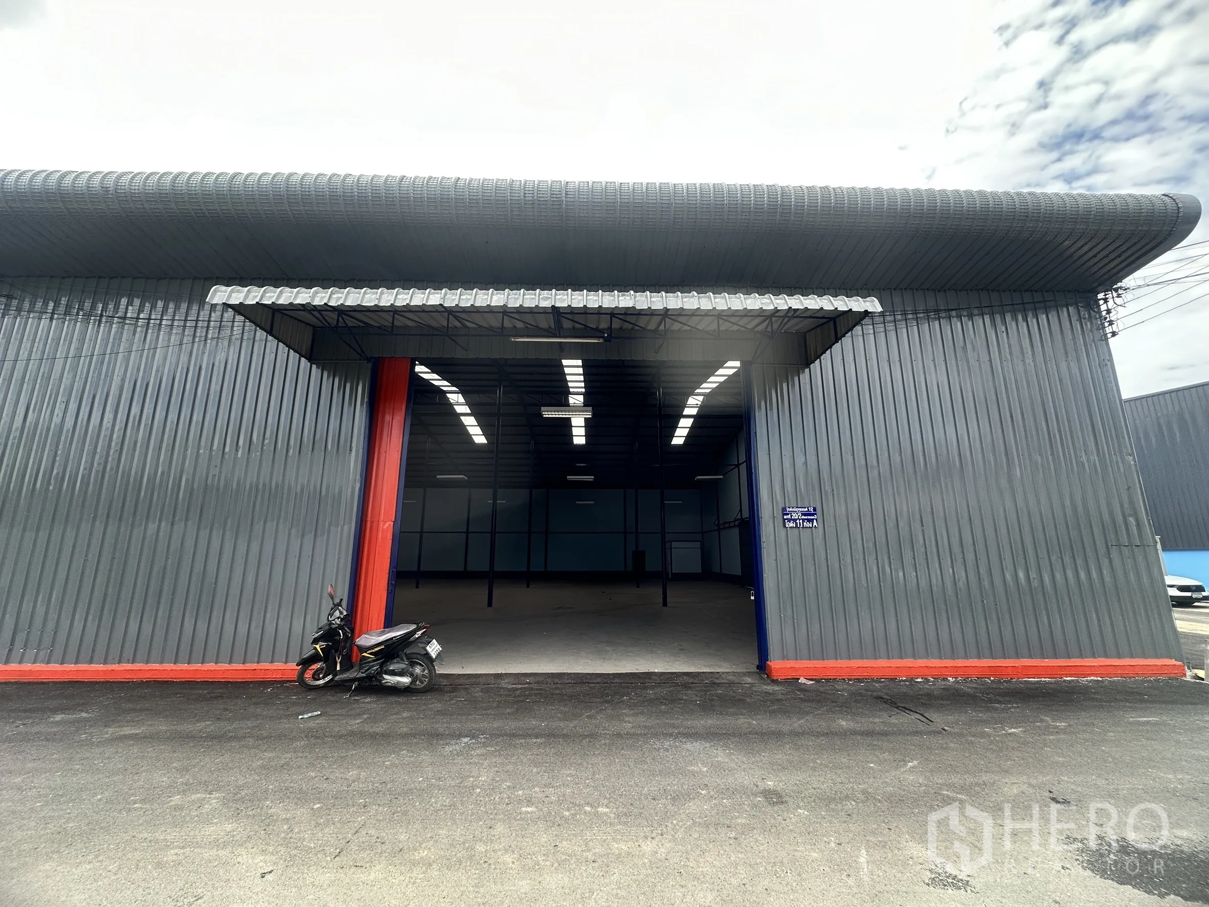 仓库 for rent in Lat Krabang, Bangkok - 建筑正面设有大型开口，车辆可直接驶入仓库。