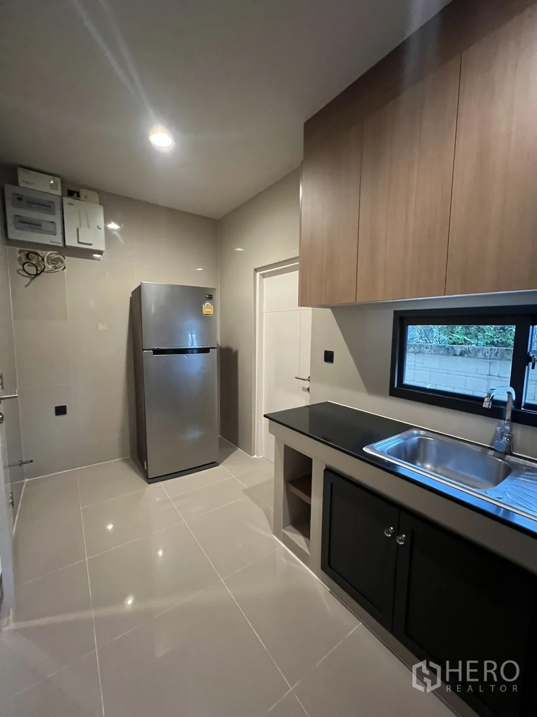 บ้าน ให้เช่าในBang Kapi, Bangkok - ครัวมุมตรงข้าม มองเห็นตู้เย็น หน้าต่าง และพื้นที่เก็บของ