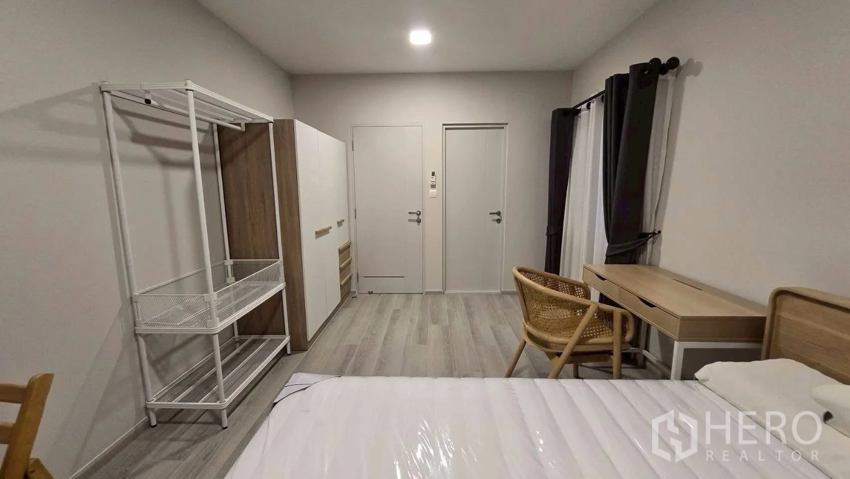 Semi-detached House for rent in Prawet, Bangkok - Bright bedroom with bed, desk, wardrobe and freestanding rack.