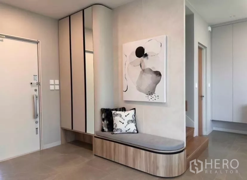 Detached House for rent in Samut Prakan - Entry foyer with built-in shoe cabinet, bench seating, and abstract wall art.