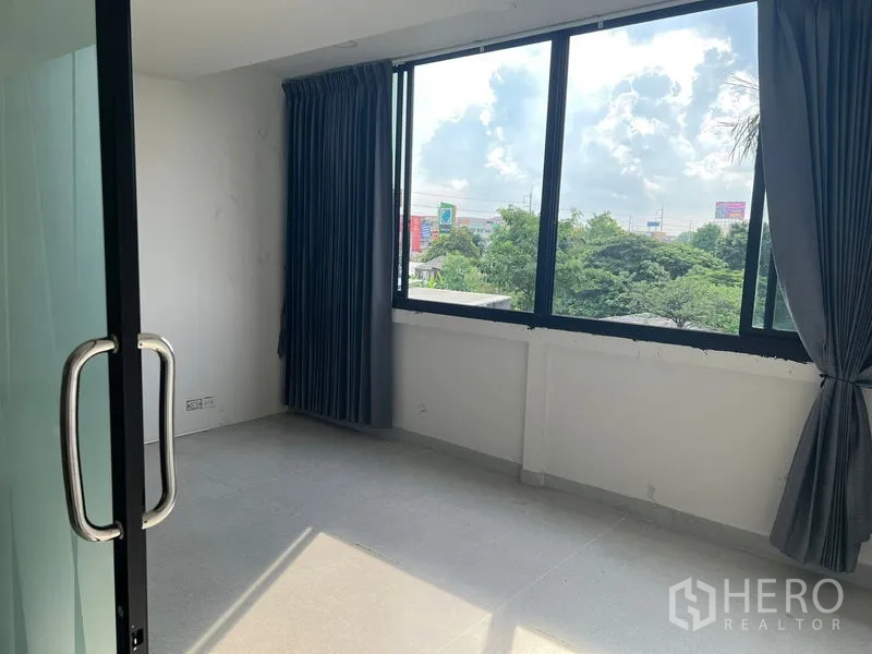Office Space for rent in Mueang Samut Prakan, Samut Prakan - Small private office with large windows and curtains overlooking greenery.