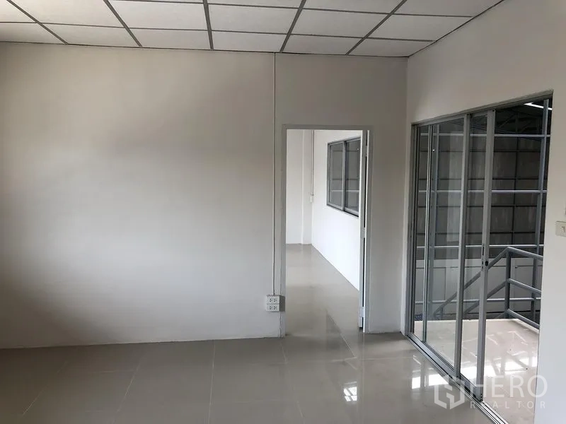 Factory for rent in Pak Kret, Nonthaburi - Second-floor office room with sliding glass doors and access to the stairs.