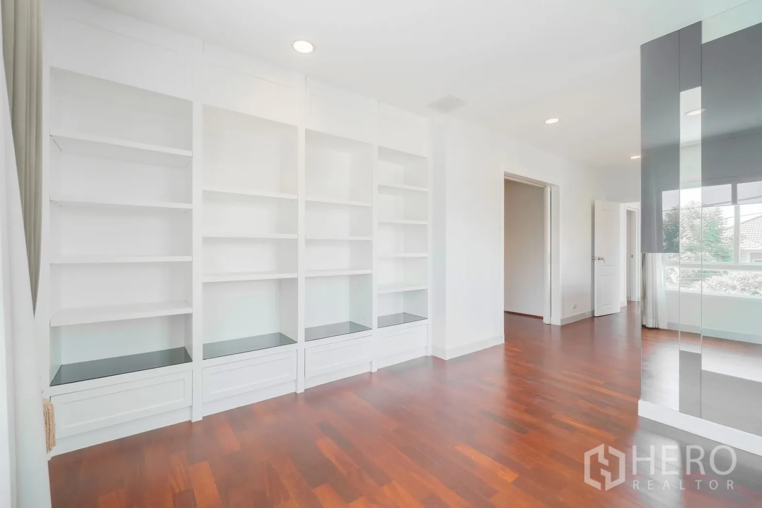 Detached House for rent or sale in Saphan Sung, Bangkok - Light room with white built-in shelving and wood floors.