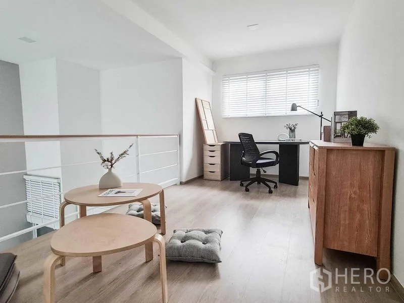 联排别墅 出租在Prawet, Bangkok - 夹层书房，书桌、转椅、收纳柜与宽窗百叶帘。