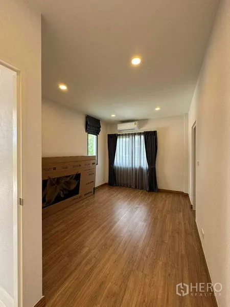 Detached House for rent in Don Mueang, Bangkok - Spacious multipurpose room with wood flooring and boxed TV near the window.