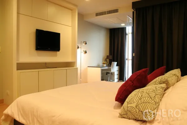 คอนโด ให้เช่าในKhlong Toei, Bangkok - ห้องนอนมีทีวีติดผนัง โต๊ะทำงานริมหน้าต่าง และผ้าม่านทึบสีเข้ม