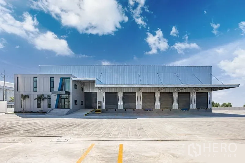 Warehouse for rent in Bang Bo, Samut Prakan - Front elevation of the warehouse showing multiple truck bays and an expansive parking apron.