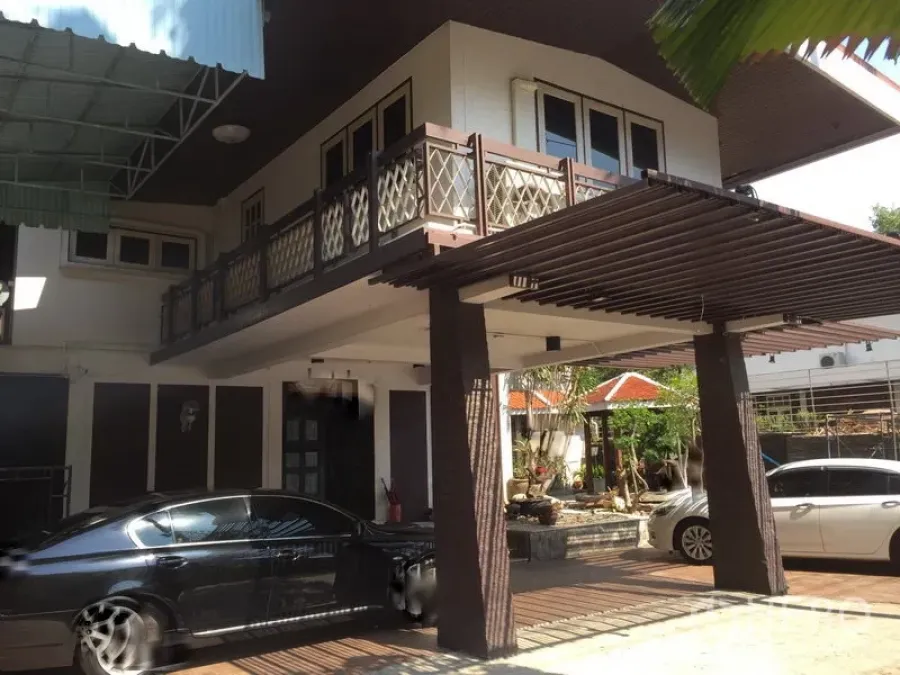 零售空间 出租在Khlong Toei, Bangkok - 两层建筑外观，带阳台与有顶车棚，院内可停多辆车。