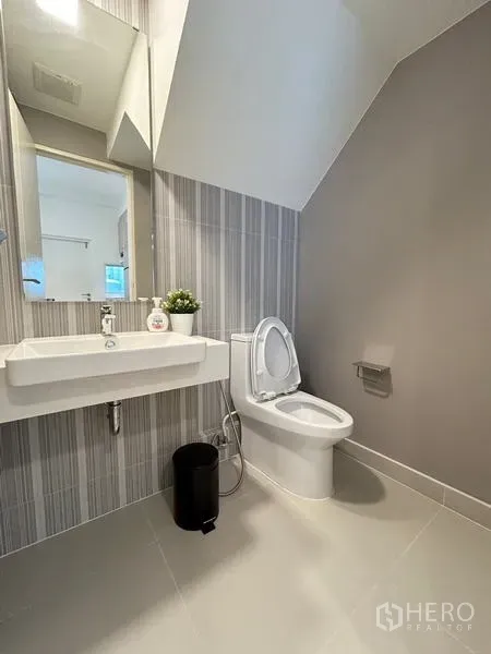 ทาวน์เฮาส์ ให้เช่า - ห้องน้ำชั้นล่างใต้บันได อ่างล้างหน้าแบบแขวนผนังและโถสุขภัณฑ์.