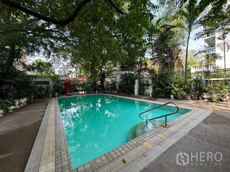 Condominium for rent in Yan Nawa, Bangkok - Outdoor swimming pool shaded by mature trees within the residence.