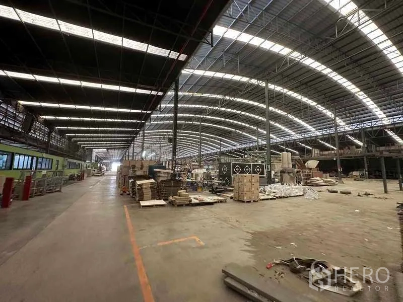 Factory for rent in Pathum Thani - Large workshop zone with mixed materials, pallets and packaging areas.