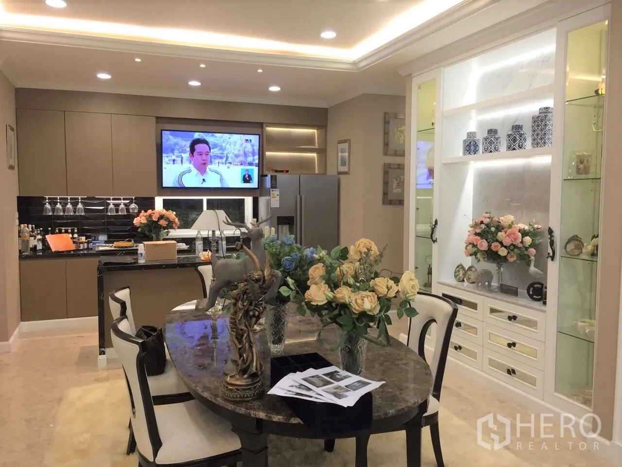 Detached House for rent or sale in Saphan Sung, Bangkok - Dining area with marble table, built-in display cabinet and open kitchen with TV