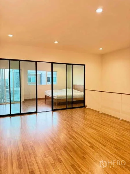 ทาวน์เฮาส์ ให้เช่าในSuan Luang, Bangkok - ชั้นมาสเตอร์กว้าง พื้นไม้ พร้อมผนังกระจกเต็มสูงกั้นพื้นที่ห้องนอน