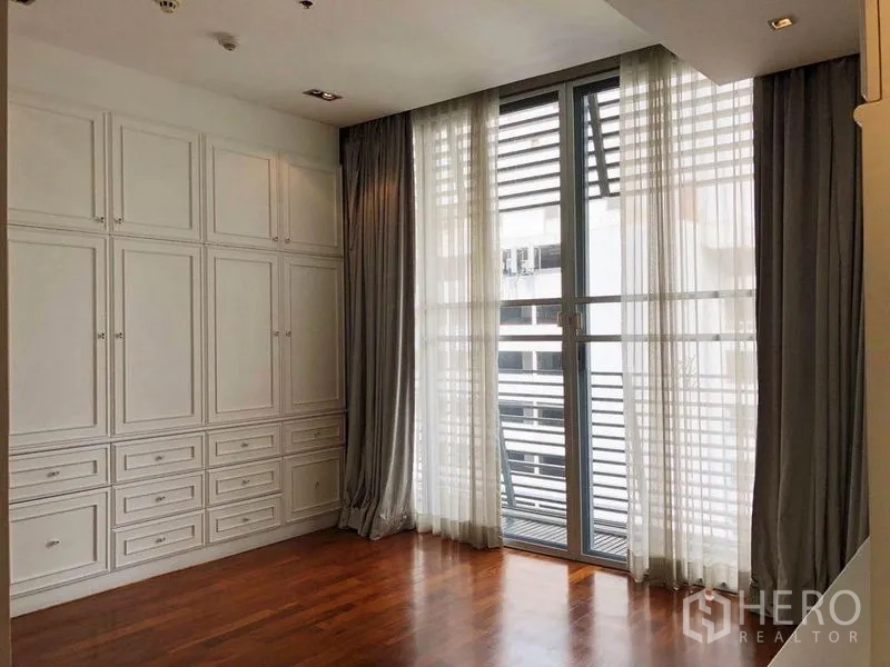คอนโด ให้เช่าในKhlong Toei, Bangkok - ห้องโล่งโปร่ง หน้าต่างสูงชนเพดาน ผ้าม่านโปร่ง และตู้บิวท์อินสีขาวเต็มผนัง