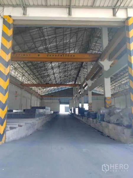 货栈 出租或出售在Ban Phaeo, Samut Sakhon - 仓库内部，高挑钢结构屋顶与行车吊沿中央通道分布