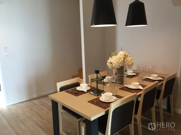 公寓 出售在Bang Rak, Bangkok - 六人餐桌与黑色吊灯，布置精致的用餐区。