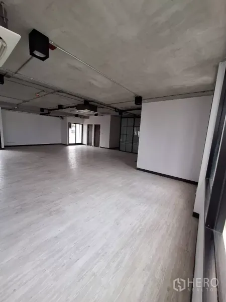 Office Space for rent in Watthana, Bangkok - Spacious workspace with bright flooring, exposed conduits, and windows on both sides.