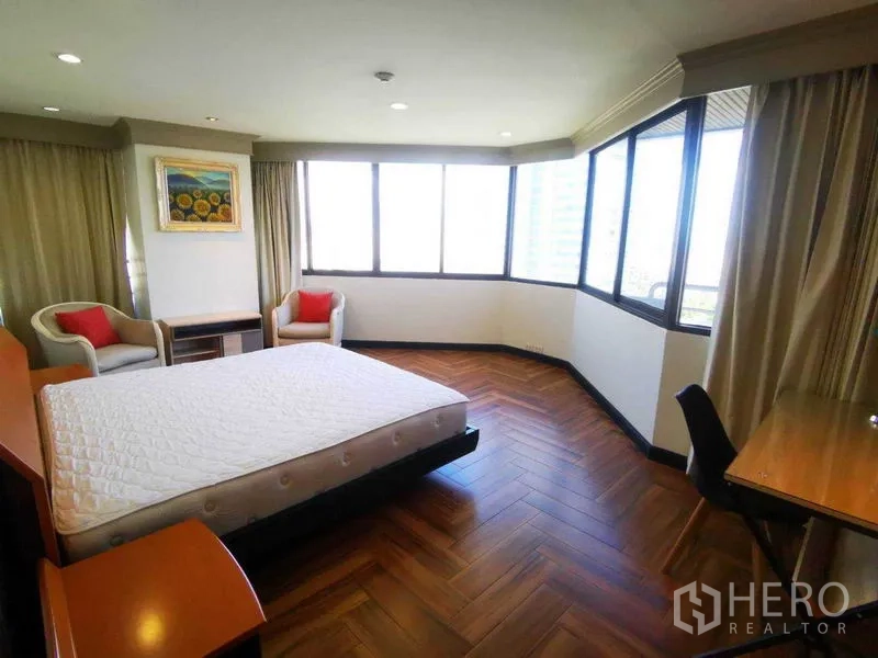 คอนโด ให้เช่าในKhlong Toei, Bangkok - ห้องนอนมุมอาคาร หน้าต่างรอบด้าน มุมพักผ่อน เก้าอี้คู่ พื้นไม้ลายก้างปลา