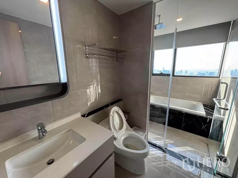 公寓 出租在Huai Khwang, Bangkok - 套内浴室，玻璃淋浴间、浴缸与观景窗。