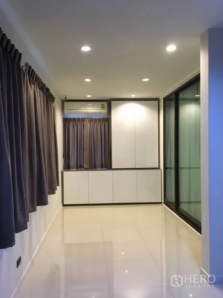 Detached House for rent or sale in Bang Kapi, Bangkok - Bright hallway with floor-to-ceiling windows, cabinetry and tiled floors.