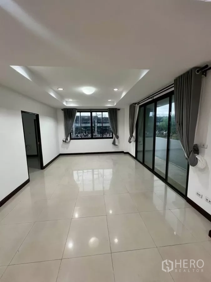Home Office for rent in Wang Thonglang, Bangkok - Spacious tiled room with recessed ceiling lights and sliding doors to a terrace.