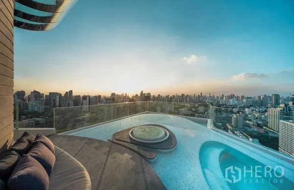 公寓 出租在Watthana, Bangkok - 日落下的屋顶无边际泳池与按摩池，眺望曼谷天际线的高层公寓景观。