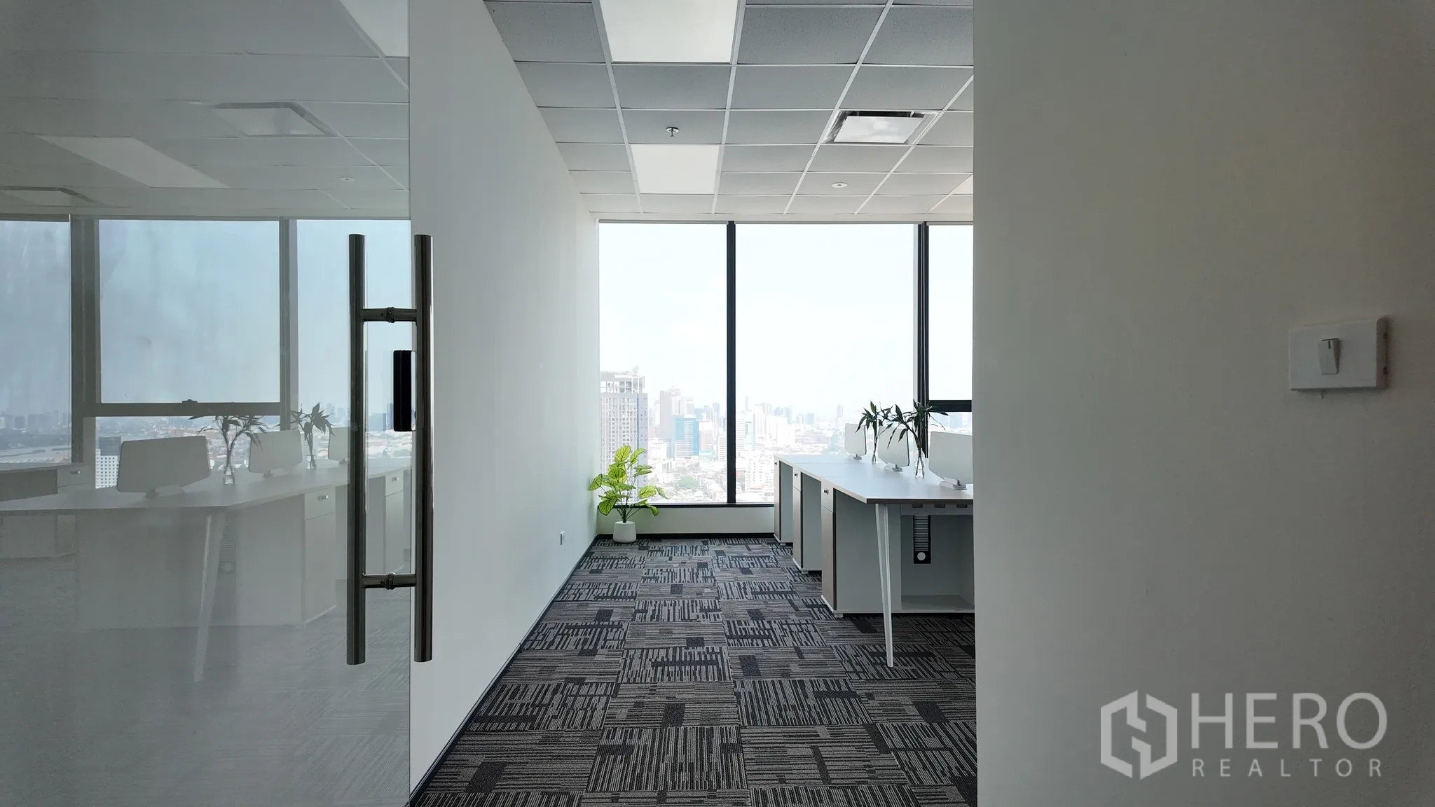 Office Space for rent in Khlong Toei, Bangkok - Entry corridor opening into a work area with tall windows and potted plants.