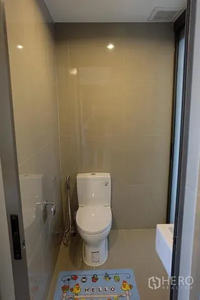 公寓 出租在Khlong Toei, Bangkok - 小巧卫浴，米色瓷砖墙面，坐便器与喷枪，采光良好。