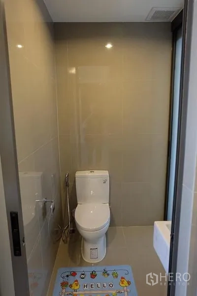 公寓 出租在Khlong Toei, Bangkok - 小巧卫浴，米色瓷砖墙面，坐便器与喷枪，采光良好。