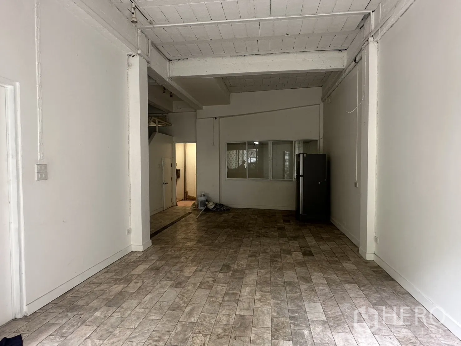 Home Office for rent in Watthana, Bangkok - Ground floor open-plan space with tiled flooring and white walls.