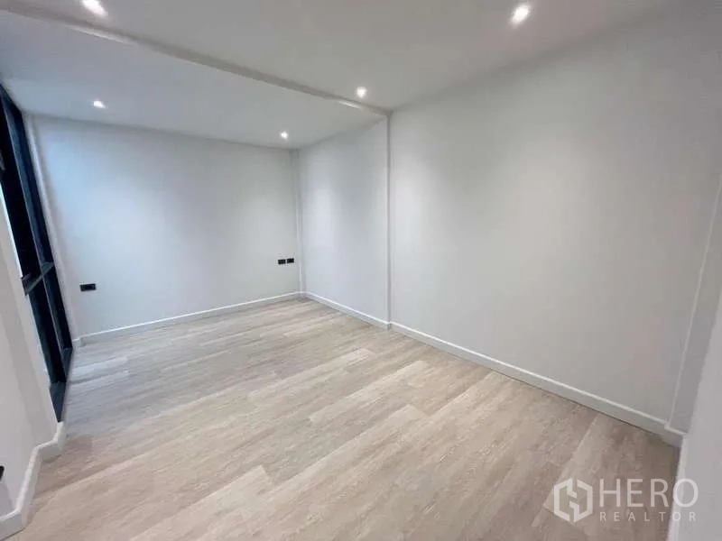 Townhouse for sale in Khlong Toei, Bangkok - Empty multi‑purpose room with recessed lights and pale timber floors.