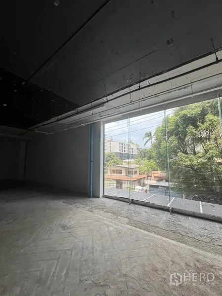 พื้นที่ขายปลีก ให้เช่า - พื้นที่ค้าปลีกมีหน้าต่างกระจกบานใหญ่รับแสงธรรมชาติ มองเห็นต้นไม้และอาคารเตี้ยโดยรอบ