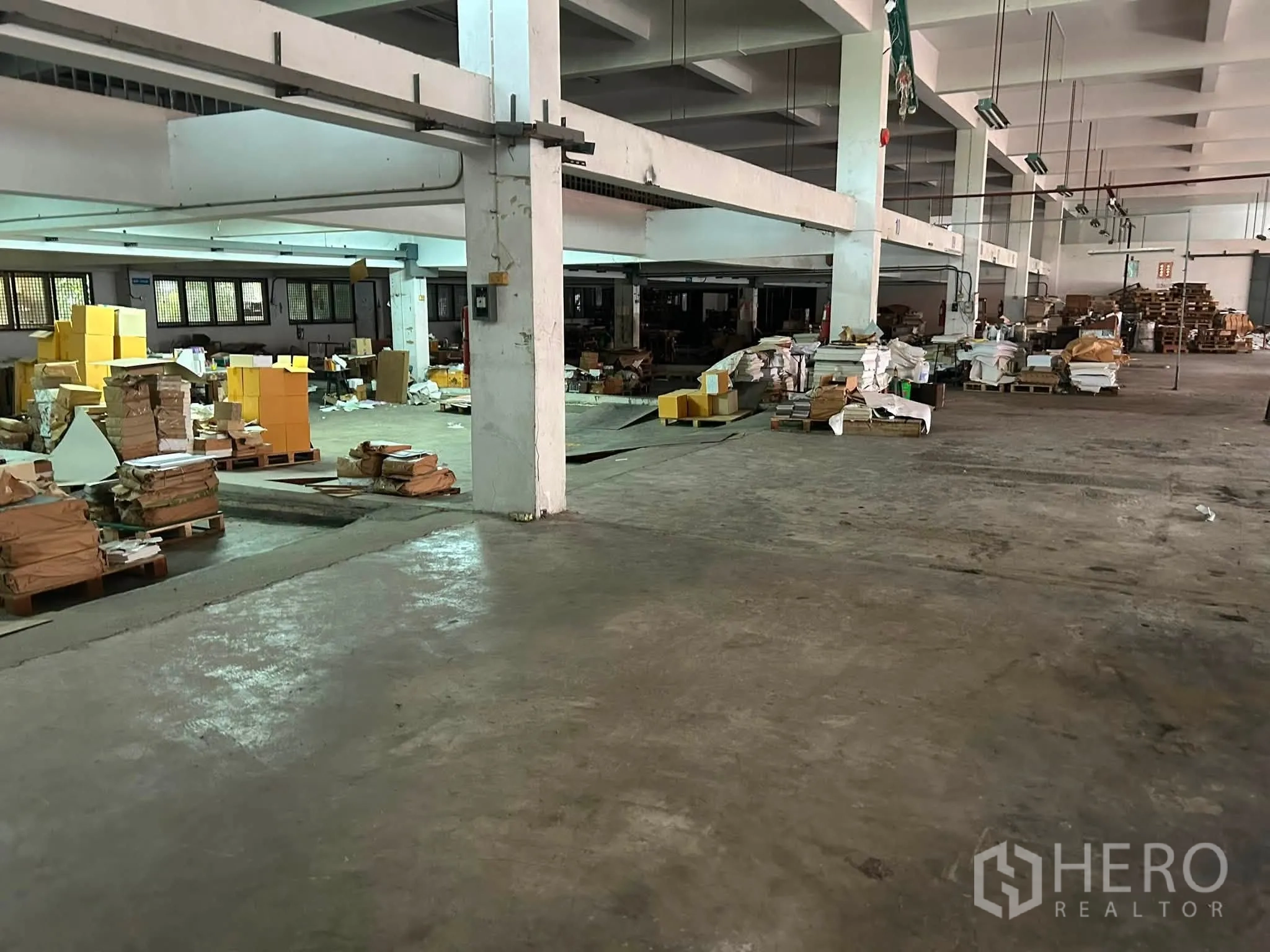 โกดัง for rent in Phra Khanong, Bangkok - โซนจัดเก็บพร้อมพาเลตและวัสดุบนพื้นโกดังขนาดใหญ่ที่มีเสาโครงสร้าง
