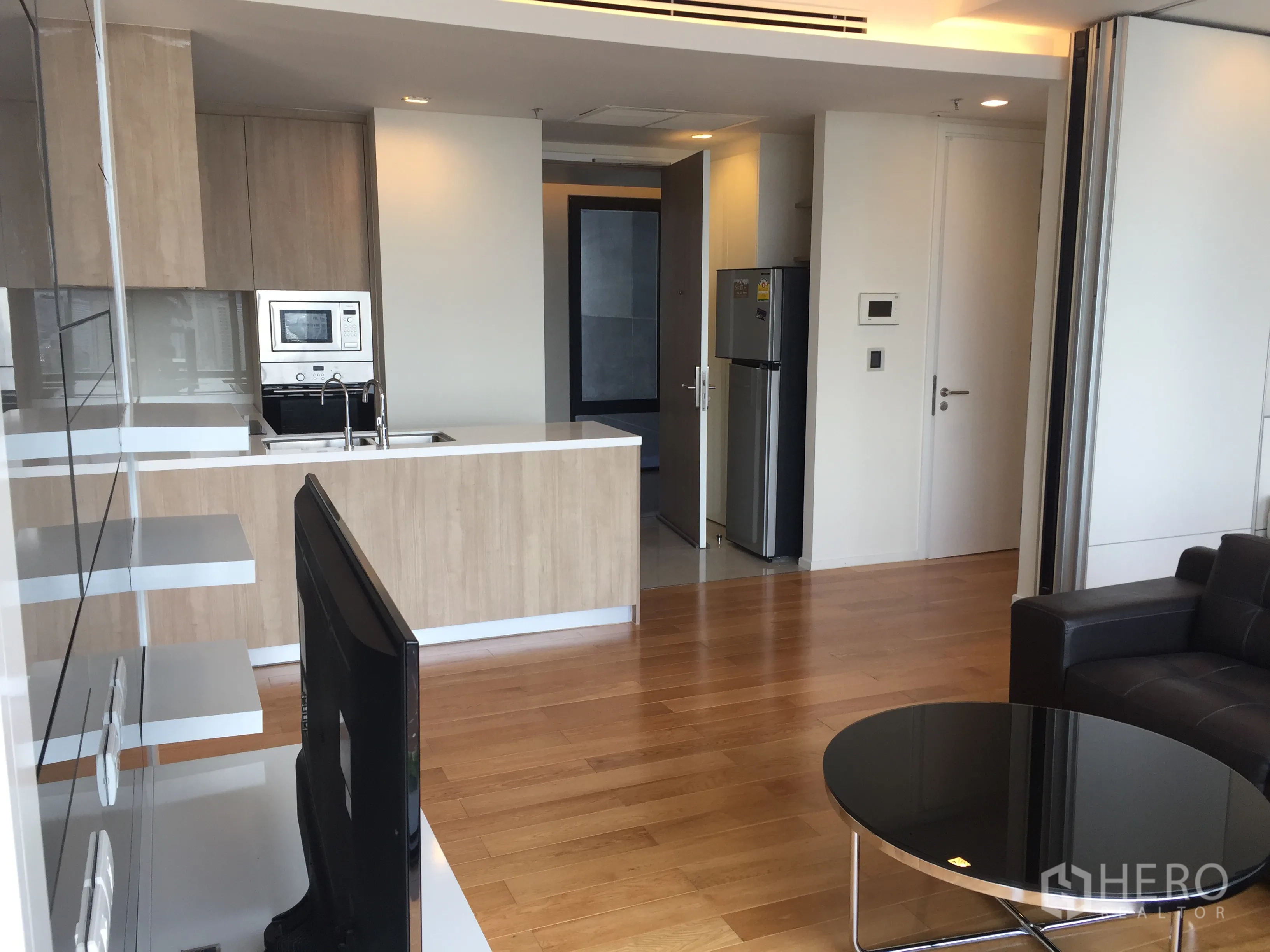 公寓 出租在Ratchathewi, Bangkok - 开放式起居区配备现代中岛厨房、嵌入式家电与木地板。