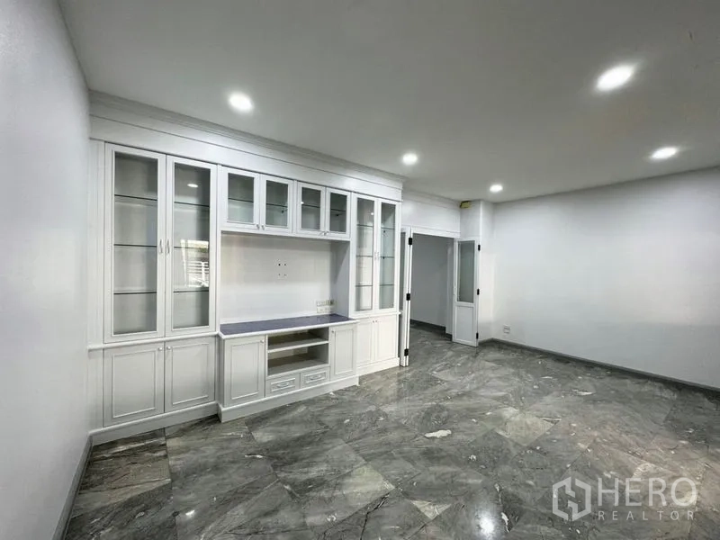 ทาวน์เฮาส์ ให้เช่าหรือขายในSuan Luang, Bangkok - ห้องนั่งเล่นพร้อมชั้นโชว์บิวท์อินสีขาวและไฟดาวน์ไลท์