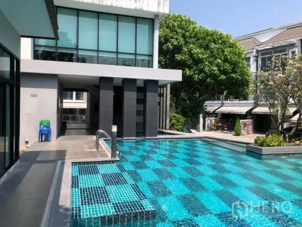 联排别墅 出租在Wang Thonglang, Bangkok - 社区会所与泳池，棋盘格马赛克瓷砖，周围绿化景观。