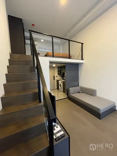 公寓 出租在Bang Rak, Bangkok - 通往夹层卧室的楼梯，俯瞰客厅，下方为紧凑厨房。