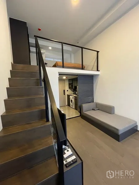 公寓 出租在Bang Rak, Bangkok - 通往夹层卧室的楼梯，俯瞰客厅，下方为紧凑厨房。