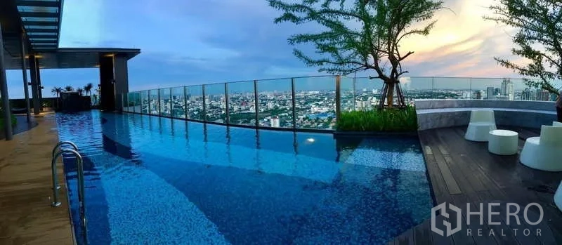คอนโด ให้เช่าในKhlong Toei, Bangkok - สระอินฟินิตี้บนดาดฟ้าเห็นเส้นขอบฟ้าเมืองและราวกระจกยามพระอาทิตย์ตก