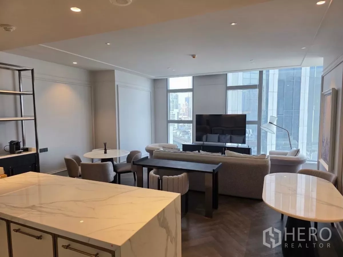 คอนโด ให้เช่า - ภาพรวมครัวและห้องนั่งเล่น พร้อมไอสแลนด์หินอ่อนและชั้นวาง