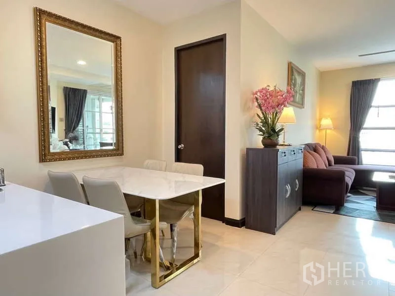 房间 出租在Khlong Toei, Bangkok - 餐区大理石台桌，旁接客厅与金色边框镜