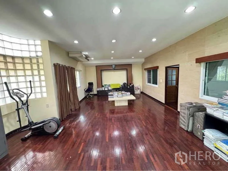 Detached House for rent in Suan Luang, Bangkok - Spacious multipurpose room with polished wood flooring, recessed lights, a work desk and exercise bike.