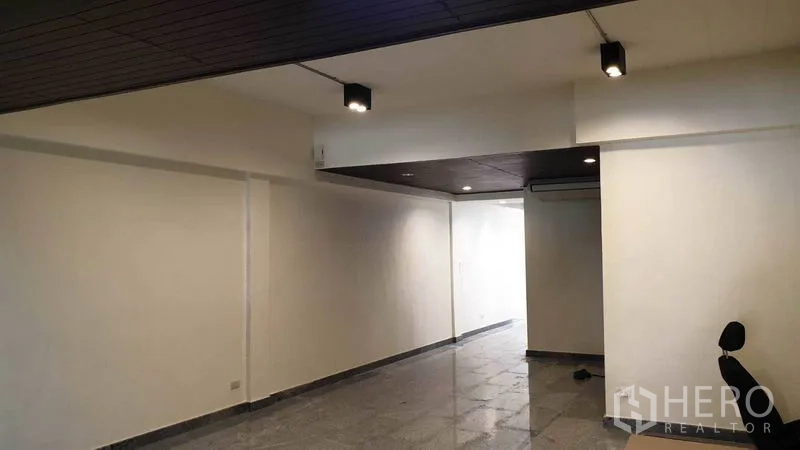 ทาวน์เฮาส์ ให้เช่าหรือขายในKhlong Toei, Bangkok - โถงชั้นล่างยาวพร้อมไฟดาวน์ไลท์และพื้นกระเบื้องเงา