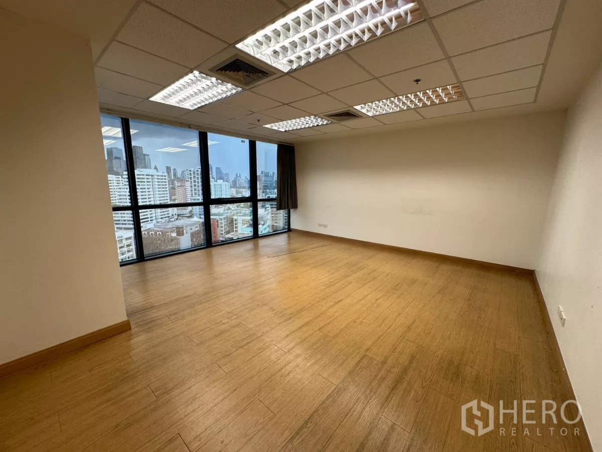 Office Space for rent in Khlong Toei, Bangkok - Medium-sized office room with skyline outlook and wood-style flooring.