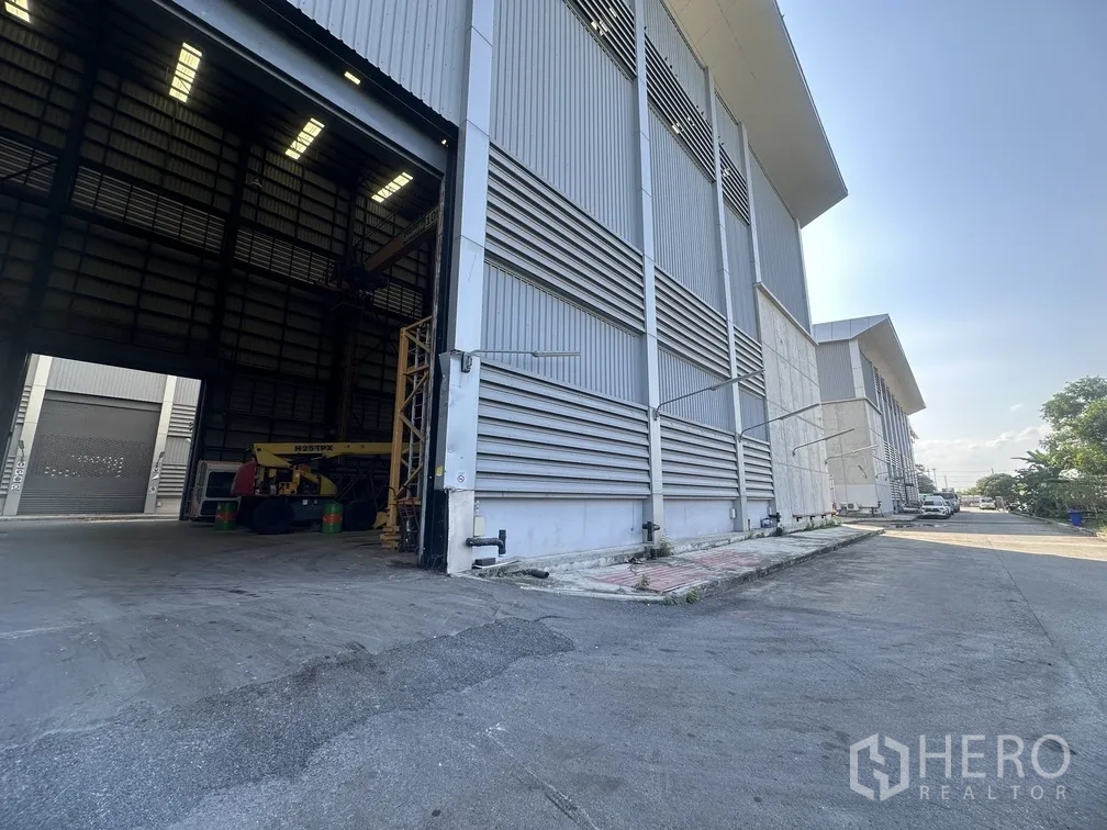 Factory for rent in Lam Luk Ka, Pathum Thani - Row of modern factory sheds with driveway for truck access.